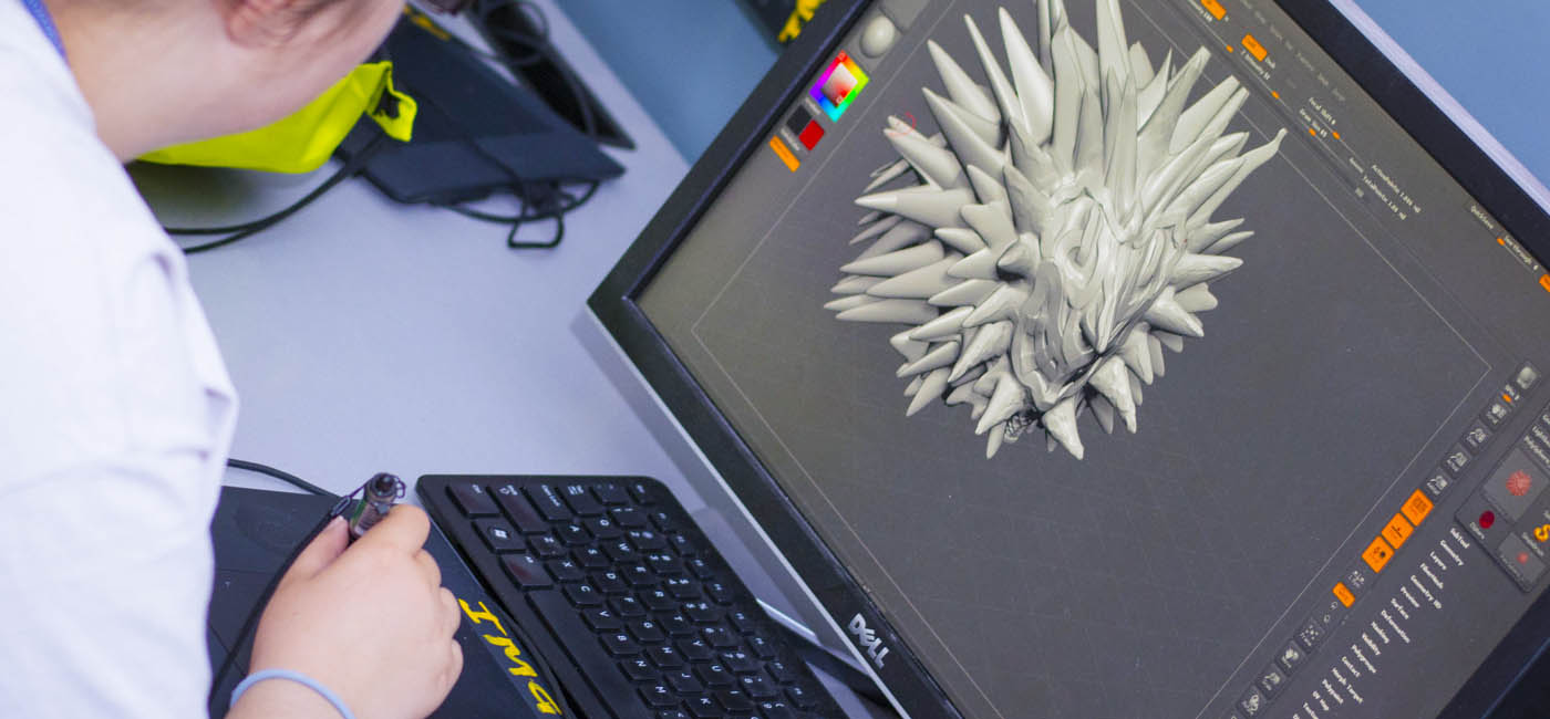 Student working on Interactive Media and Game Development art on computer