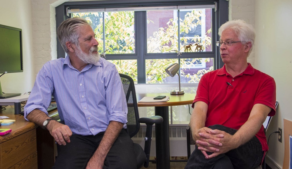 Robert Hersh and Mike Elmes sitting in an office on chairs conversating
