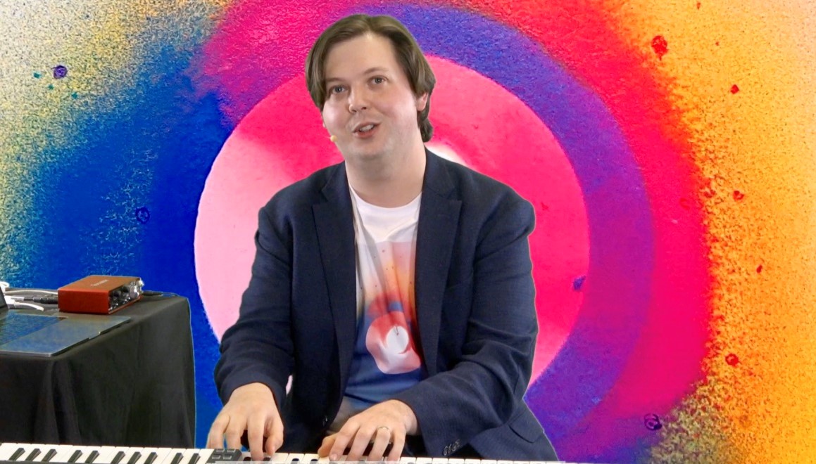 David Ibbett plays piano in front of space backdrop