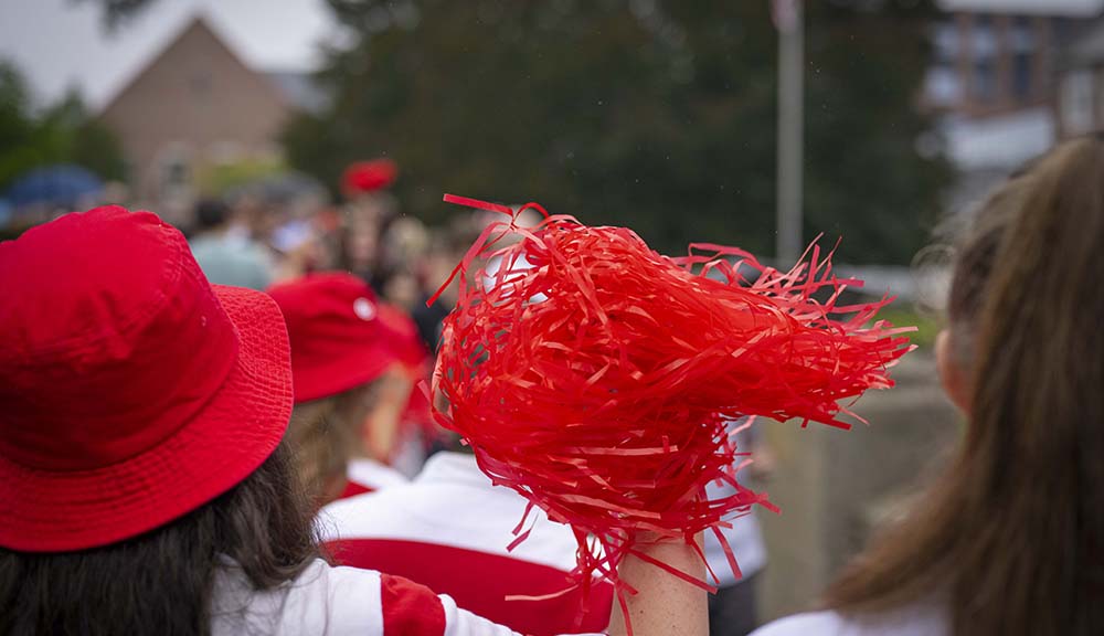 A student holds up a red pom-pom during WPI’s bridge crossing event.