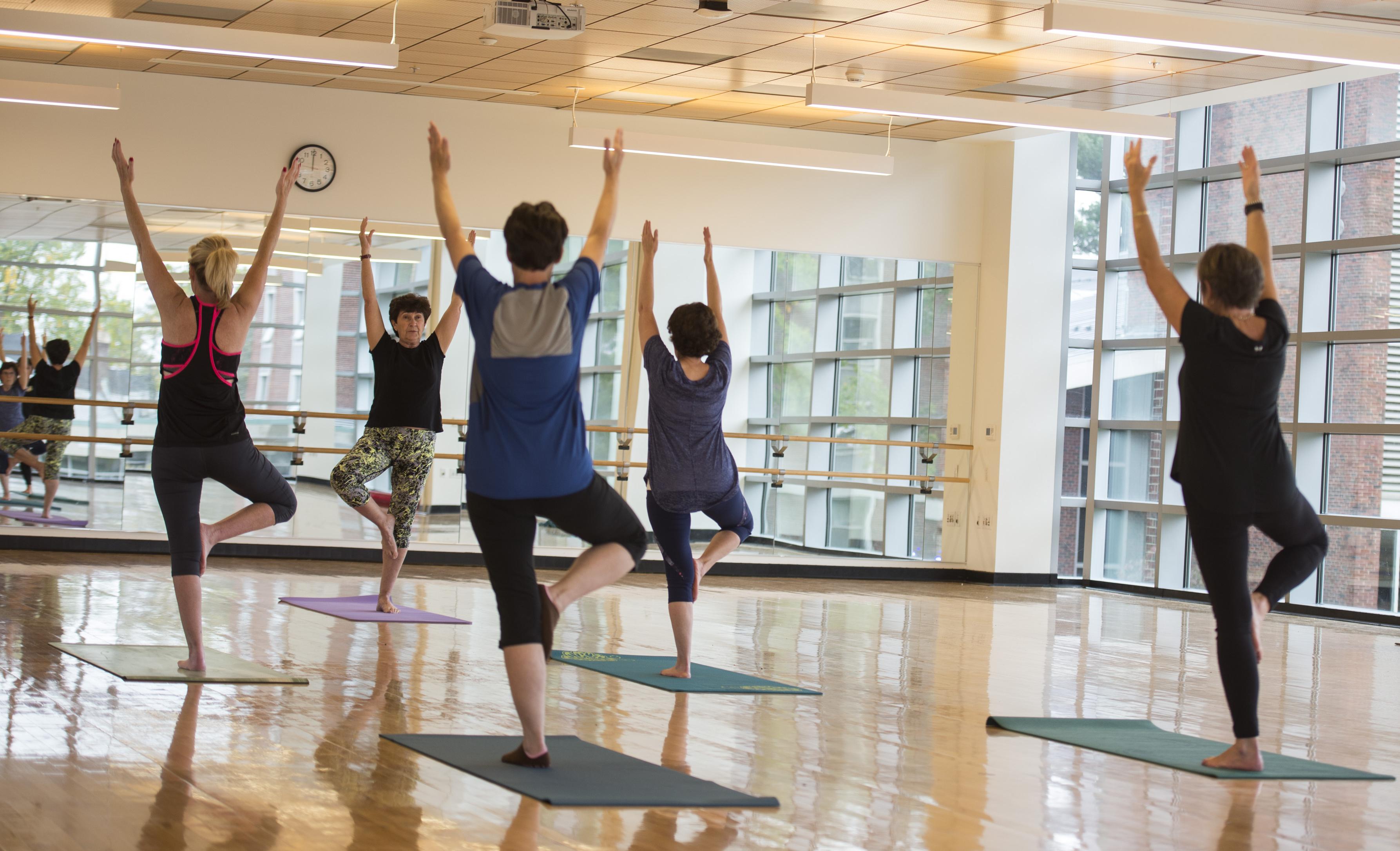Students being taught Yoga in the gymnasium studio.