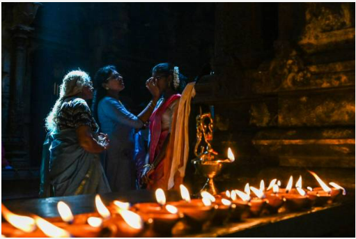 A devotee wears vermillion powder after offering prayers during Hindu festival of Diwali.
