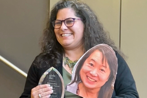 Katie Bilotta holding award &amp; Kathy sign since she accepted the award