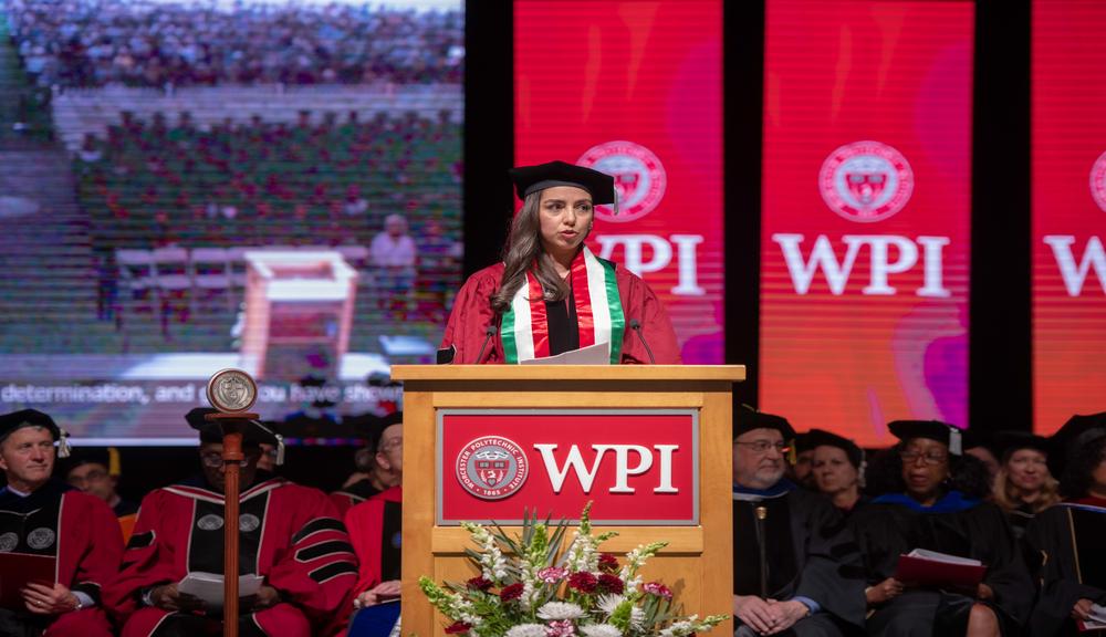 Mahvash Jebeli wearing a red commencement gown and black commencement cap at a podium for post commencement story