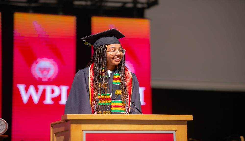 Susanna Oppong in a black cap and gown in front of a podium for post commencement story