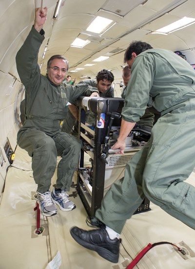 Jamal Yagoobi, left, floats beside a prototype of the EHD pump during a test on the Vomit Comet.