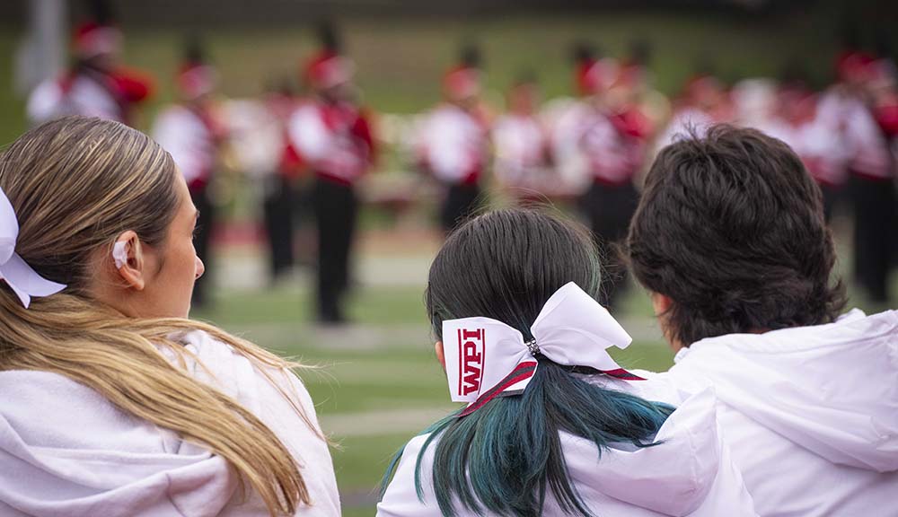A photo of students, one of whom is wearing a WPI ribbon in their hair.