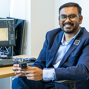 Nitin Sanket at his desk with robobees for AI research