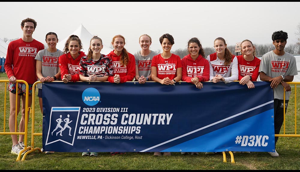 Members of the cross-country team smile together with a banner after winning a championship.