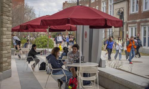 Students sitting at a table outside on campus