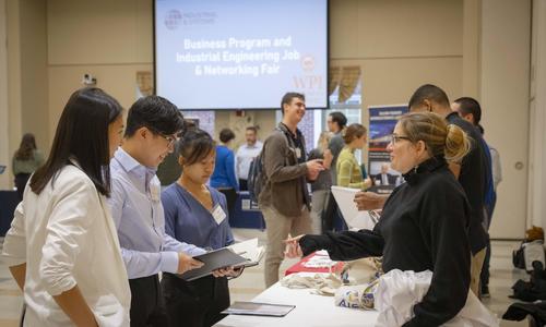 Group of students and professionals networking at a job fair hosted by The Business School at WPI