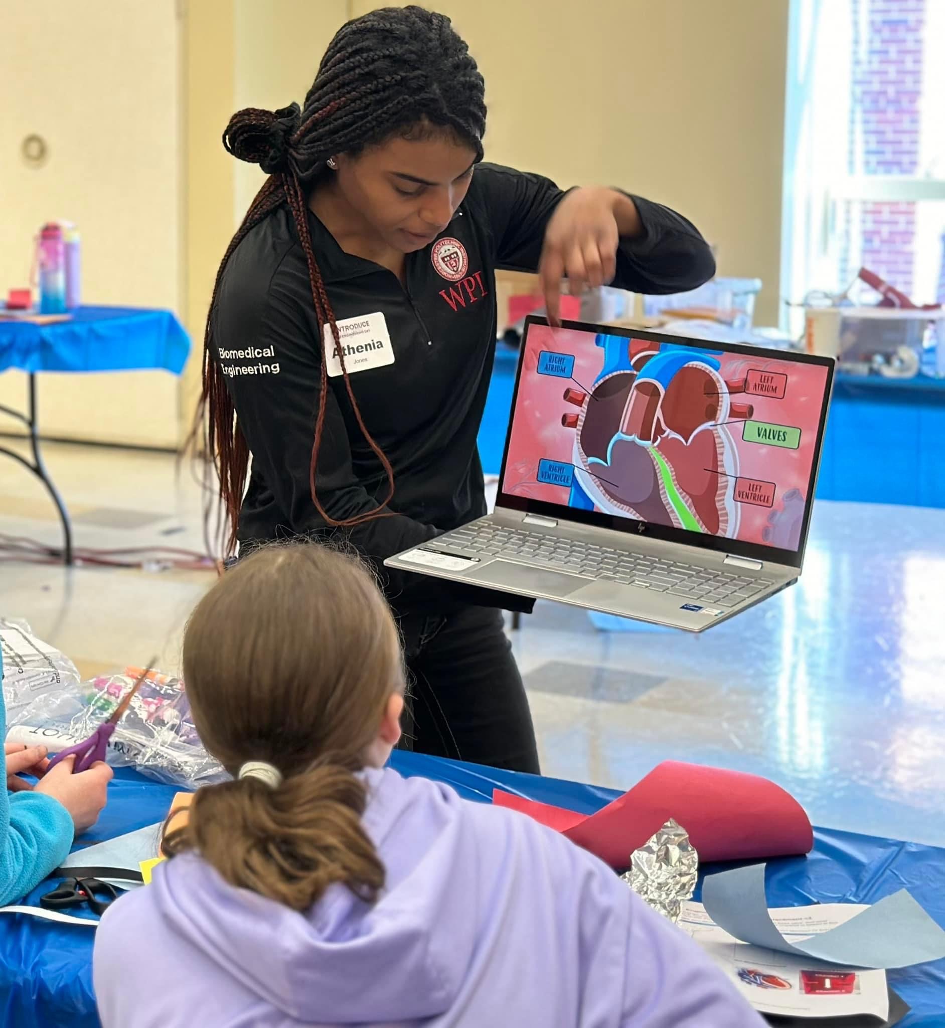 Graduate Biomedical Engineering student showing students an image of the heart while explaining the function of the heart valve