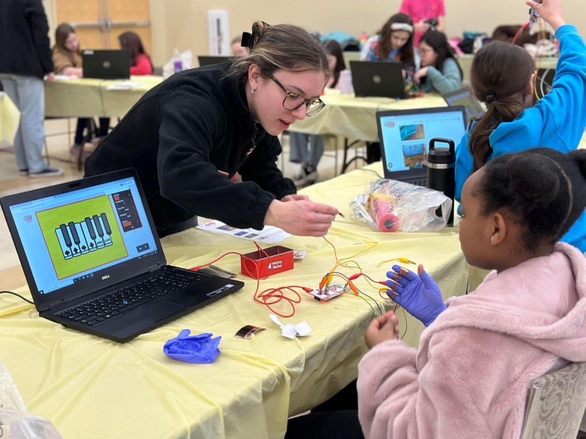 Engineering Ambassador helping students create a closed loop circuit