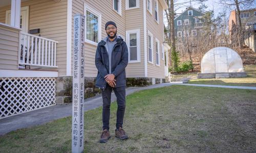 Kalvin Cummings standing next to a peace pole