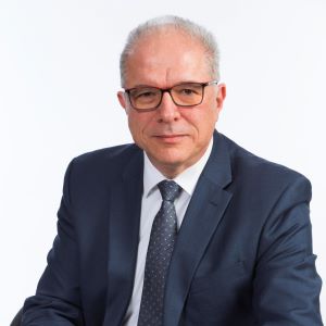 Bogdan Vernescu headshot in a blue suitcoat, white shirt, and blue tie