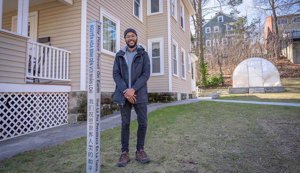Kalvin Cummings poses with the new Peace Pole outside the CRC.