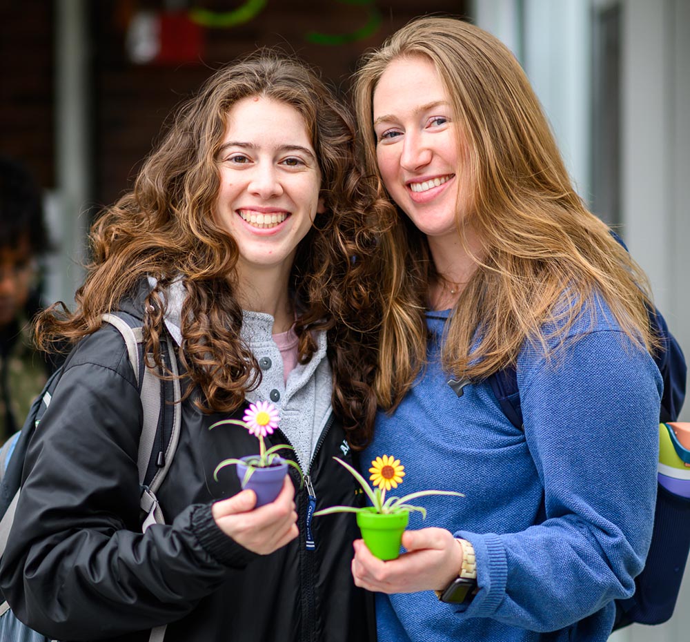 Students smile with their plants during a Wellness Day activity.