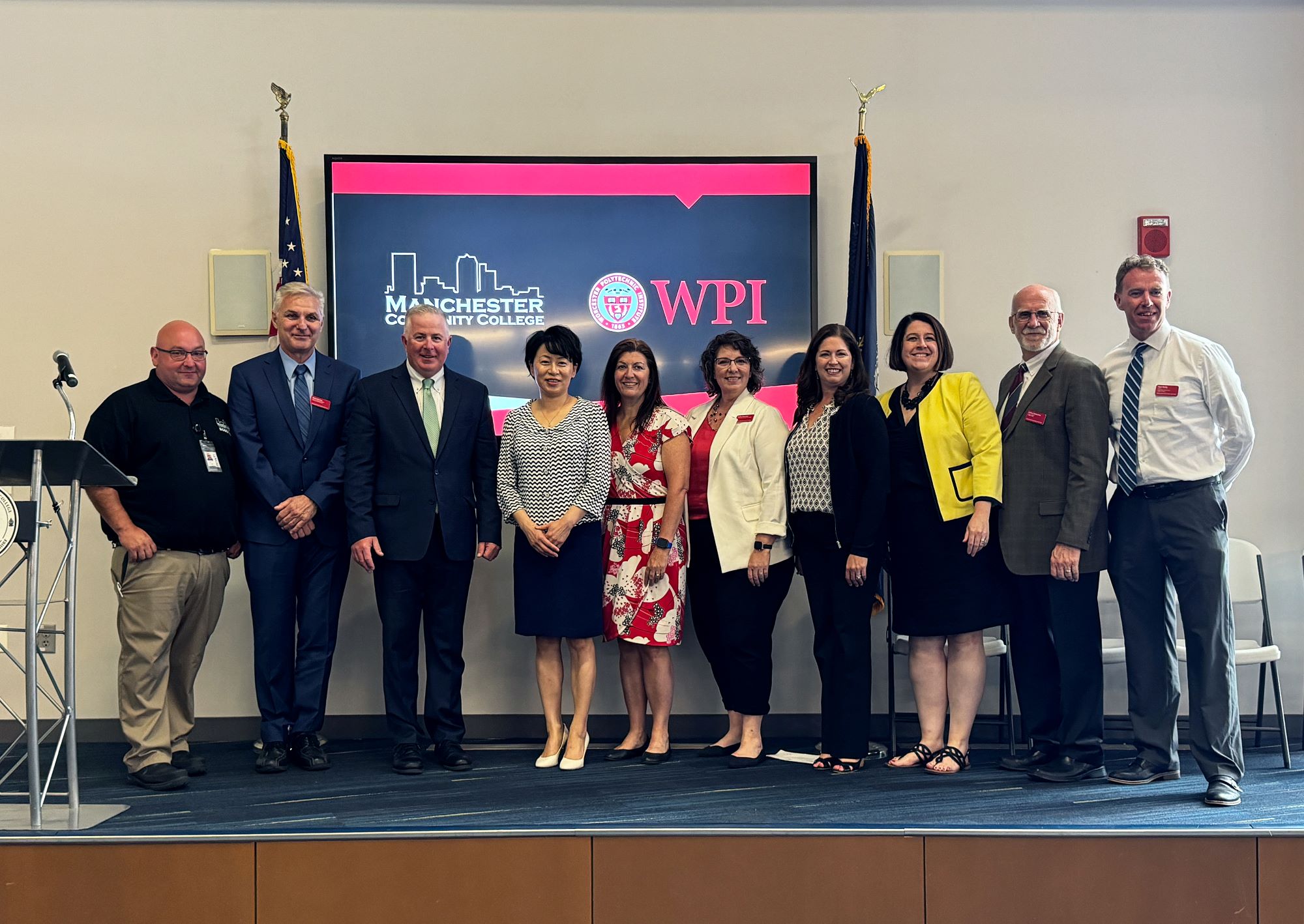 WPI and MCC officials stand on stage