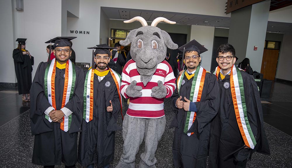 Recent graduates smile with Gompei.