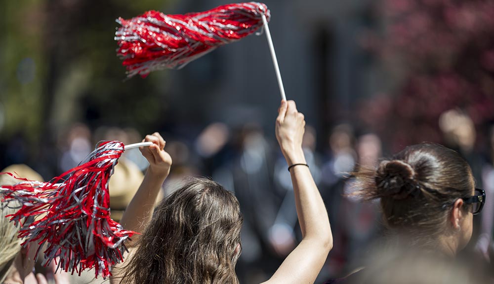 A staff member waves red and white pom poms during this year’s bridge crossing.