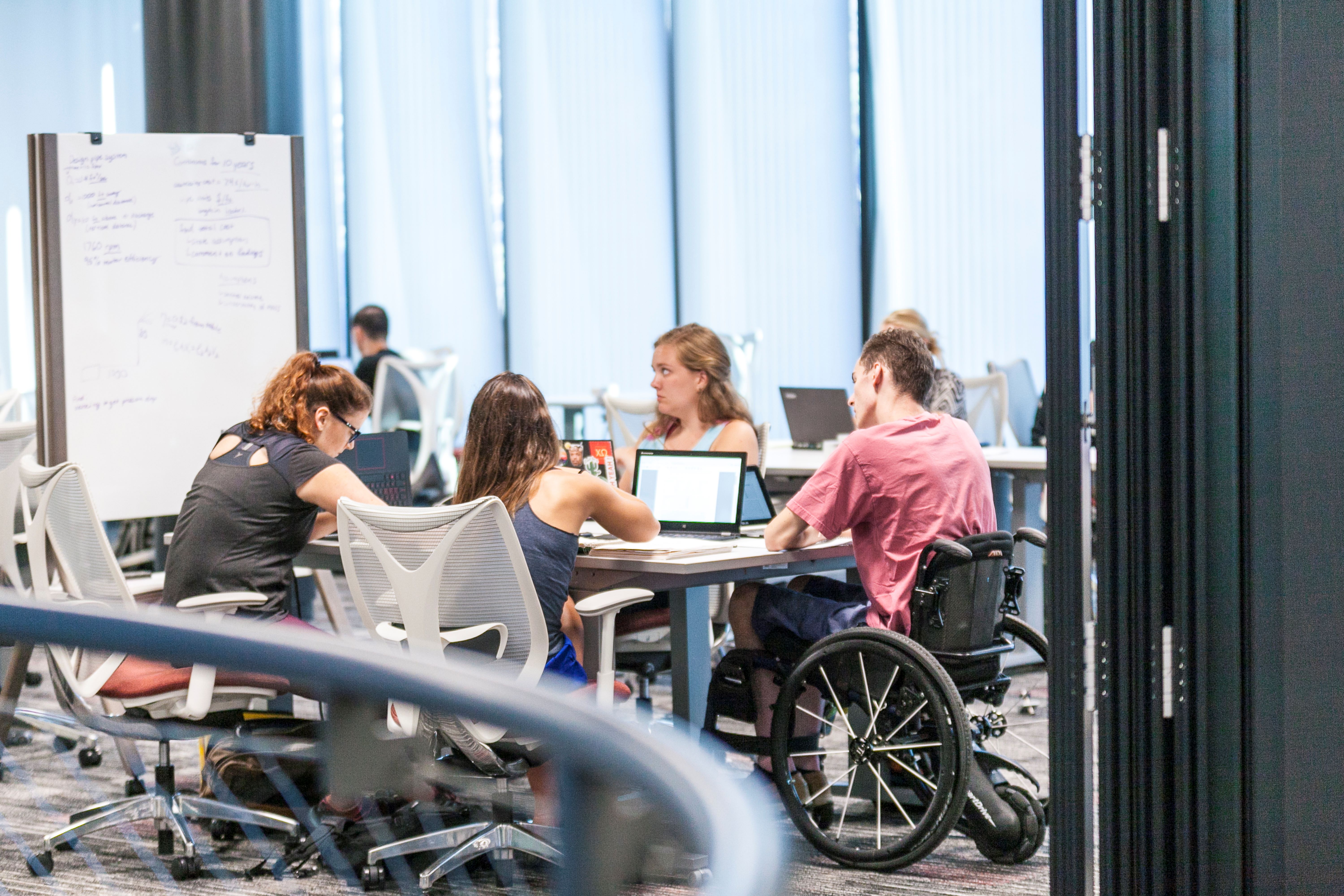 students around table with wheelchair
