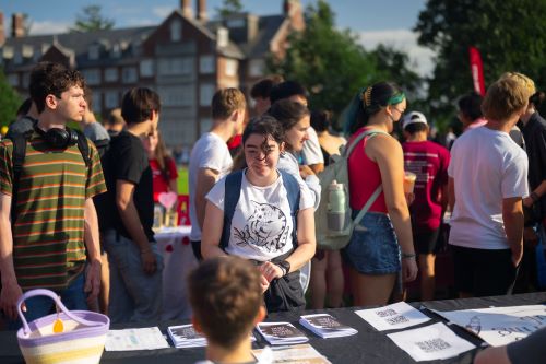 Students at an activities fair talking across a club’s table set up
