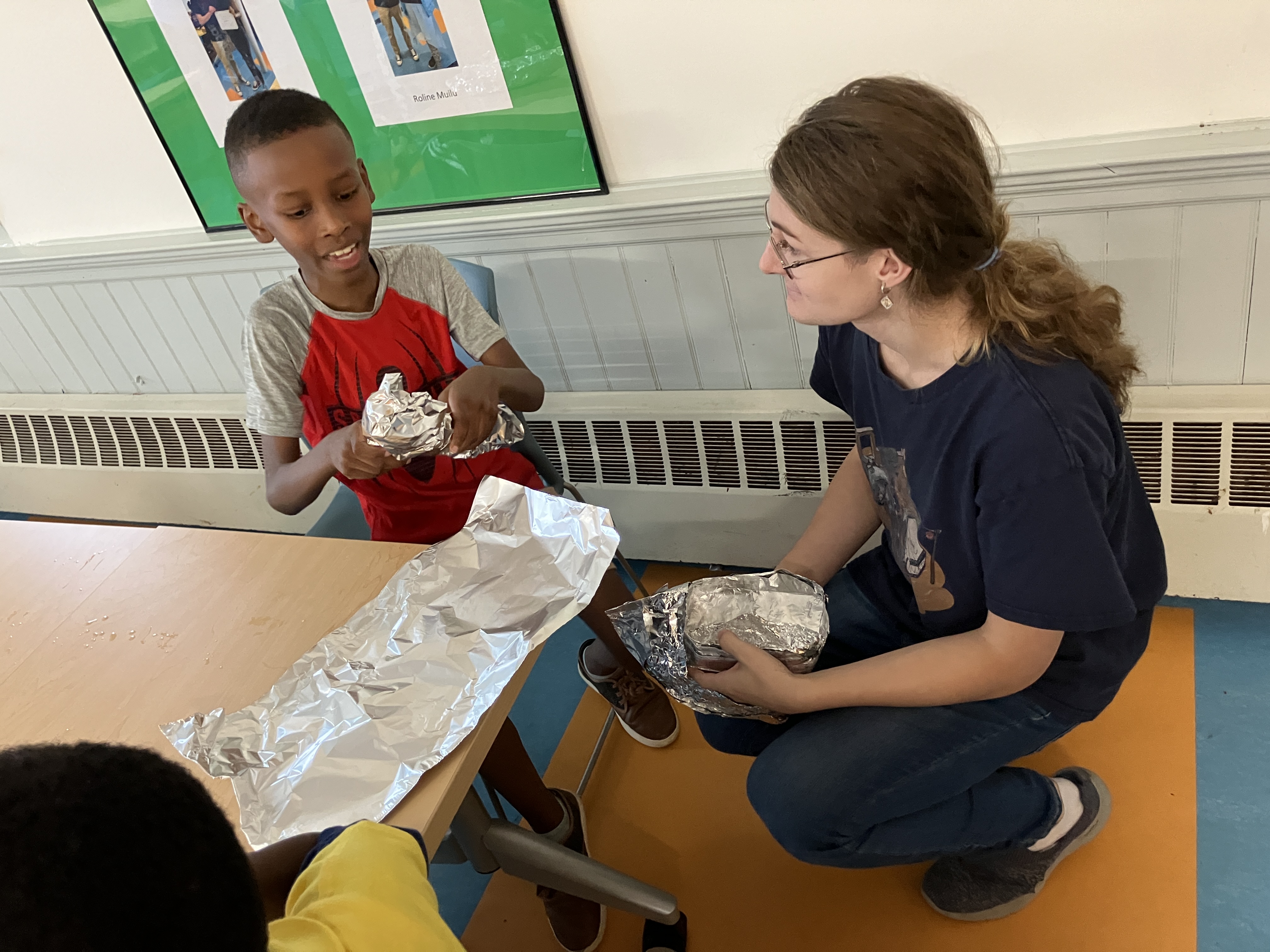 Evelyn Hubbard assisting a student with the boat design.