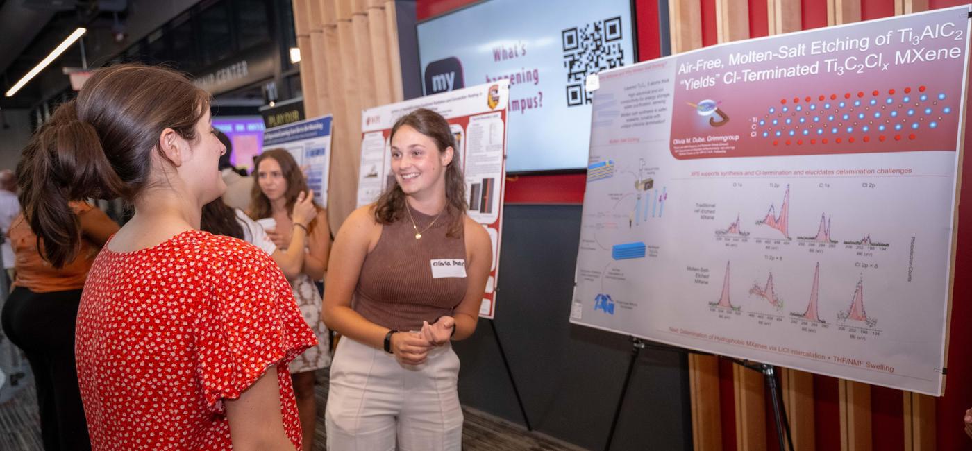 student presenting her research on a poster
