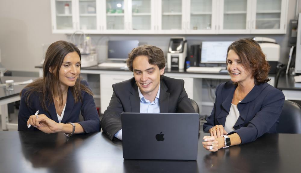 3 people looking at laptop