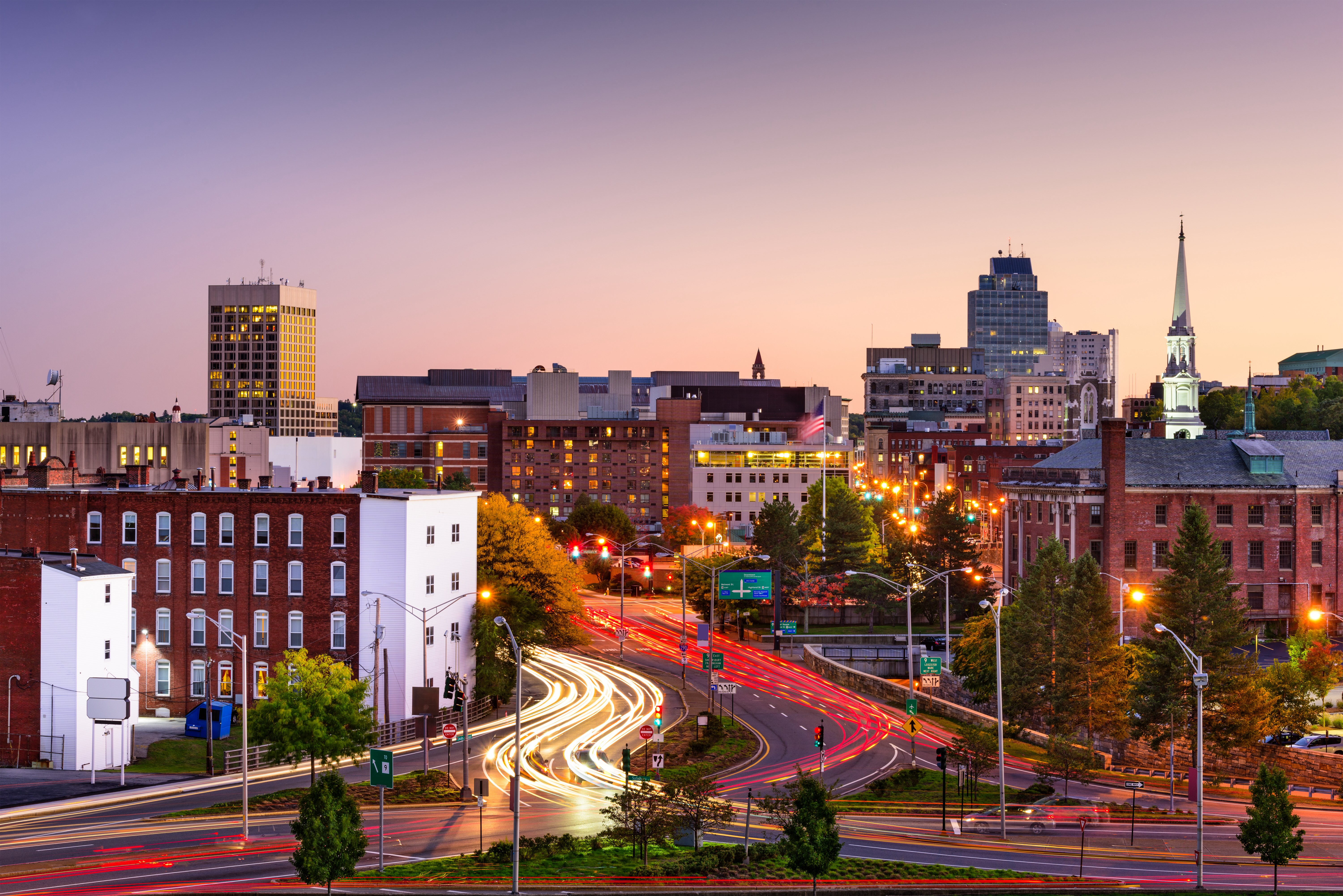 Skyline view of Worcester, Massachusetts, at sunset shows tall buildings and busy streets