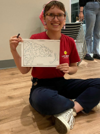 Student holding up drawing artwork