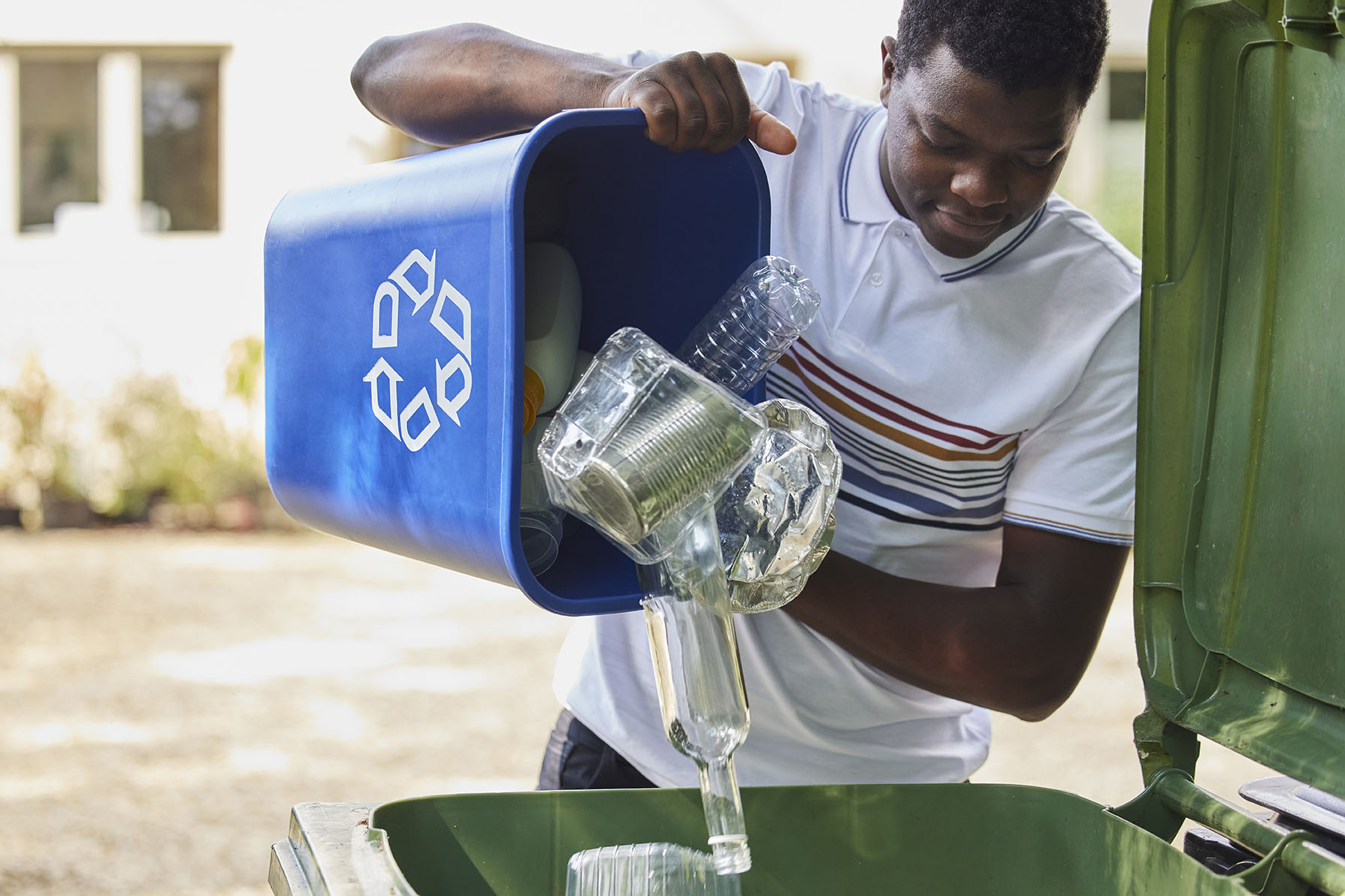 Man dumping out recycling bins.