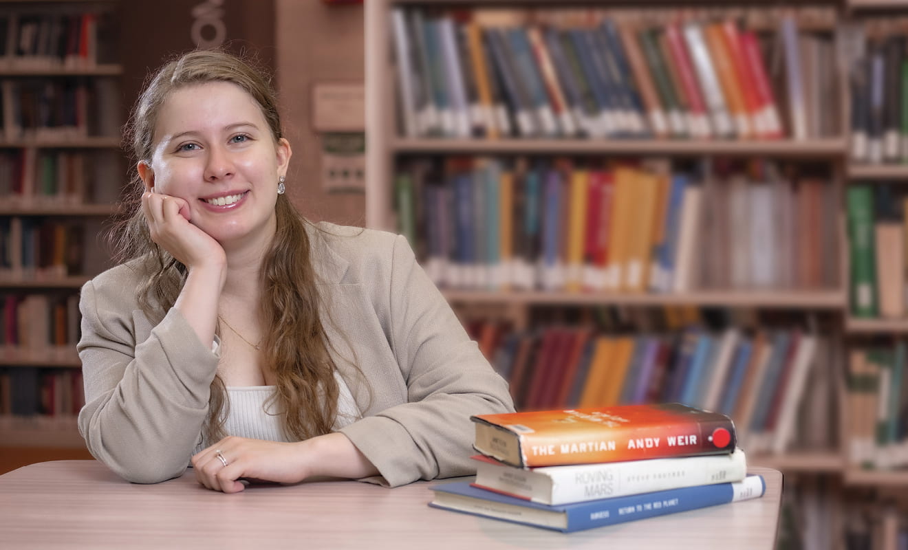 woman sitting at table with books