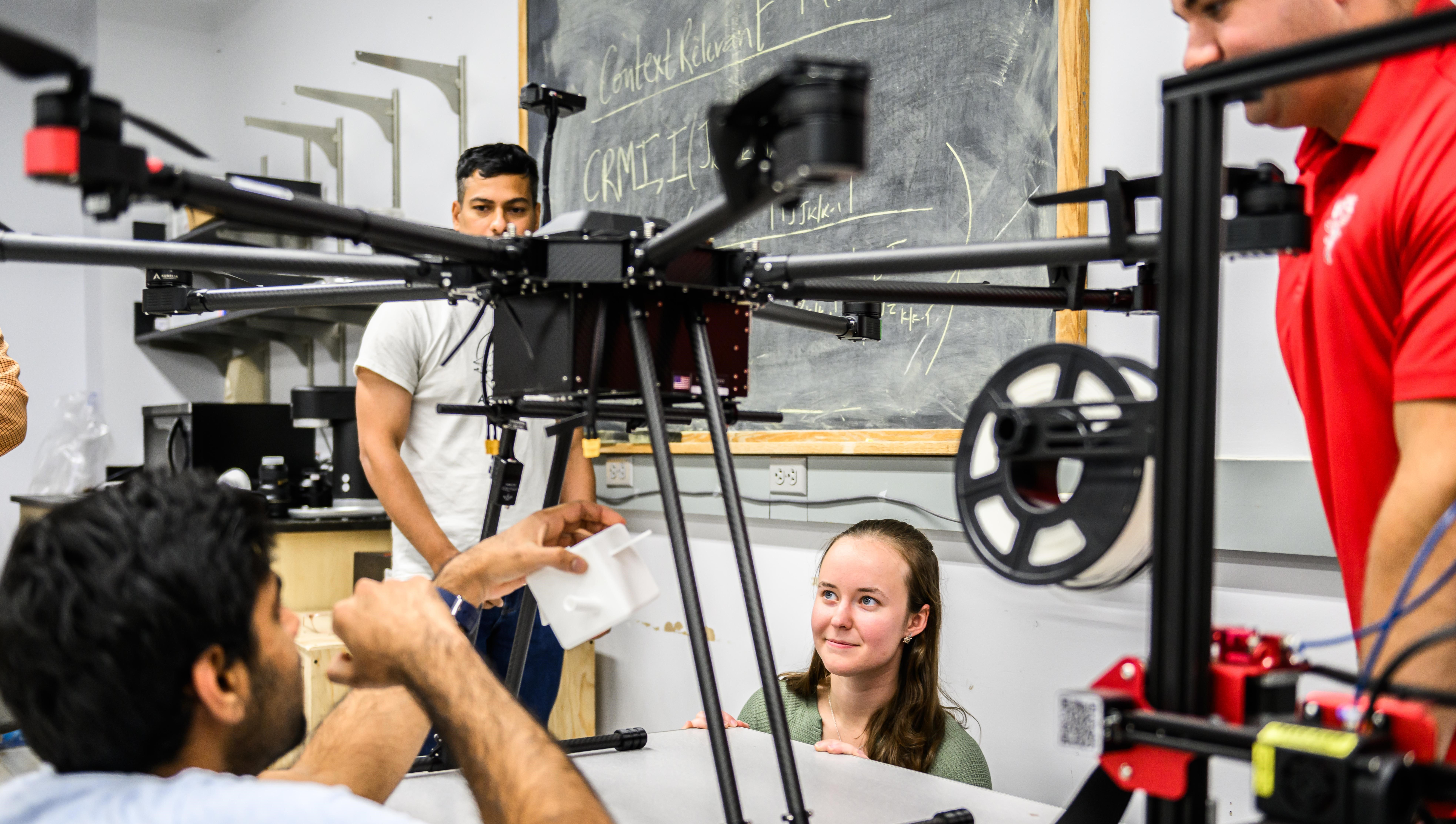 Students in a lab work on a drone.