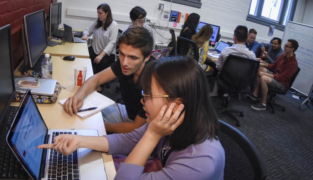 Professor Emdad reviewing data on computer with student