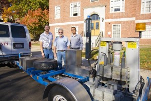 PhD student Ryan Worsman, left, Donald Pellegrino, CEE lab manager, and Rajib Mallick with a falling weight deflectometer to detect hidden flood damage