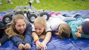 Children lined up for the chance to have a small rover drive over them.