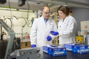 Horizons host Adam Shaw listens while Professor Marion Emmert describes a lab process.