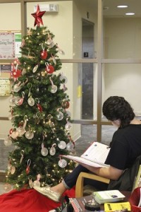 A student looks through one of the binders listing the children requesting gifts through WPI’s Giving Tree holiday program.