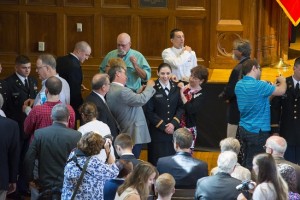 The family of cadet Julia Hartzell pin her gold 2nd lieutenant bars on her uniform.