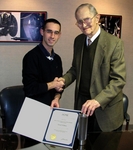 With his ASME award for student manufacturing and design, WPI senior David Willens, of Holden, Mass., shakes the hand of Howard Greis, president andCEO of Worcester-based Kinefac Corp.
